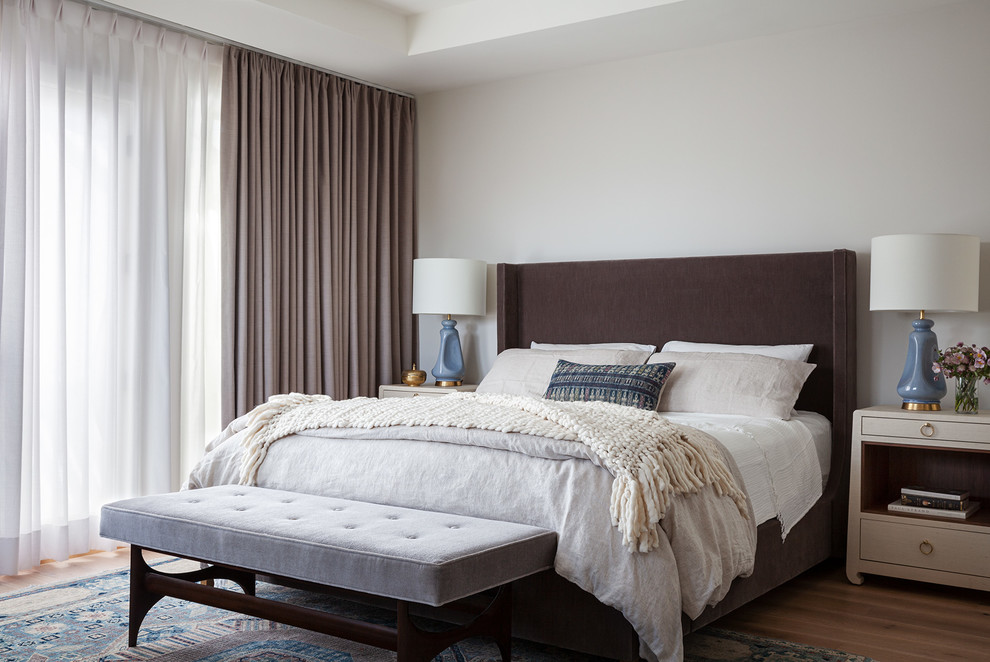 На фото: хозяйская спальня в стиле неоклассика (современная классика) с белыми стенами, паркетным полом среднего тона и коричневым полом