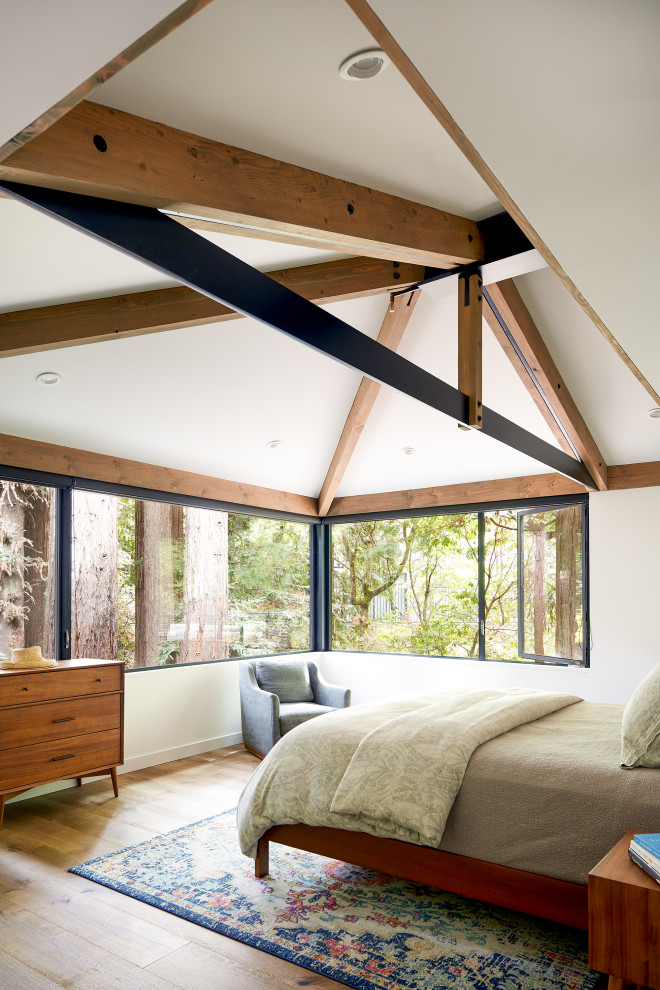 Maritimes Schlafzimmer ohne Kamin mit weißer Wandfarbe, braunem Holzboden, freigelegten Dachbalken und gewölbter Decke in Sacramento