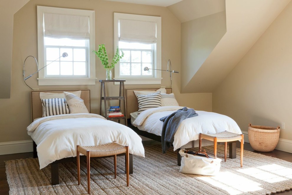 Idée de décoration pour une grande chambre d'amis tradition avec un mur beige et un sol en bois brun.