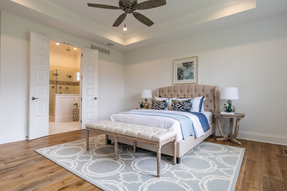 Klassisches Hauptschlafzimmer mit weißer Wandfarbe, braunem Holzboden und braunem Boden in Kansas City