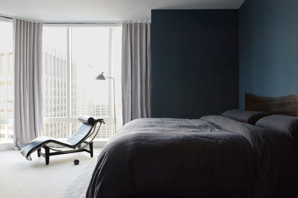 Photo of a large scandi guest bedroom in New York with blue walls, carpet, no fireplace and beige floors.