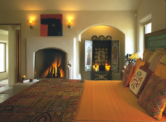 Mittelgroßes Mediterranes Hauptschlafzimmer mit beiger Wandfarbe, Kamin, verputzter Kaminumrandung, Betonboden und beigem Boden in Albuquerque