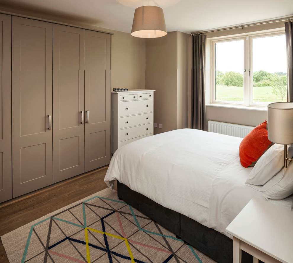 Ejemplo de dormitorio principal contemporáneo de tamaño medio con paredes grises y suelo de madera clara