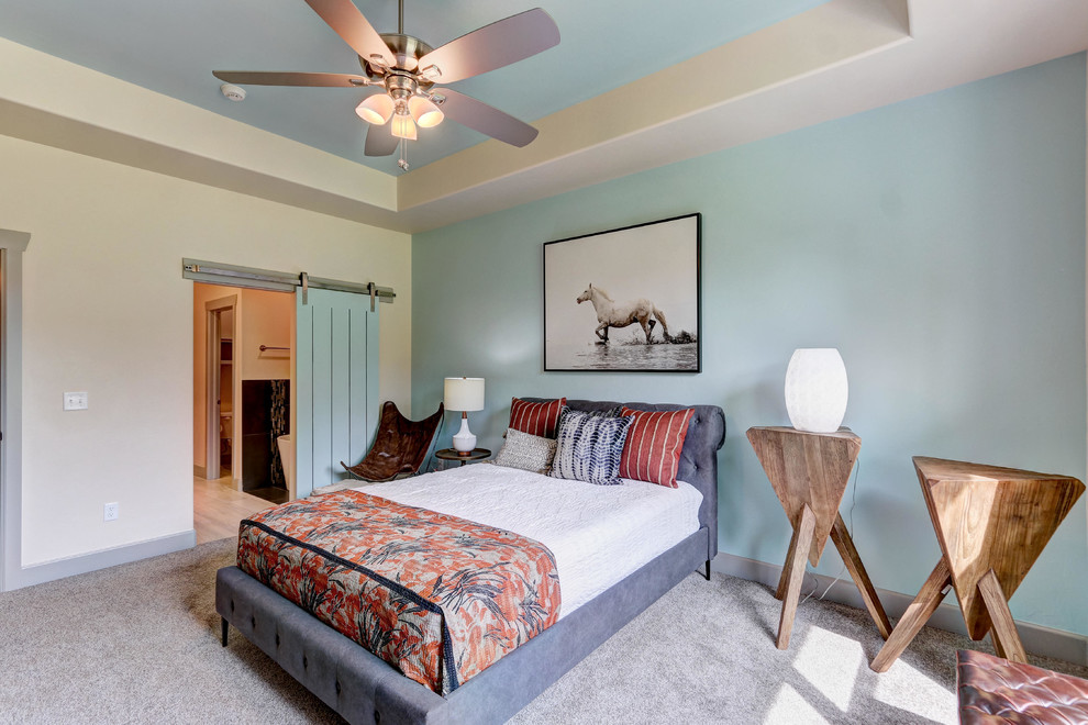Photo of a farmhouse grey and teal bedroom in Oklahoma City with blue walls, carpet and grey floors.