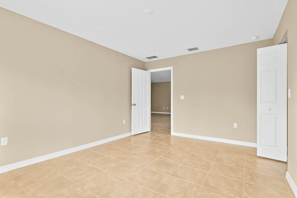 Inspiration for a mid-sized timeless master ceramic tile and beige floor bedroom remodel in Orlando with beige walls