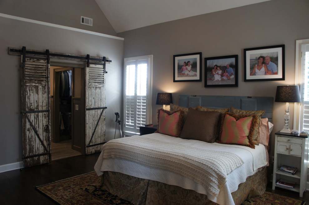 Imagen de dormitorio principal rústico de tamaño medio sin chimenea con paredes grises, suelo de madera oscura y suelo marrón