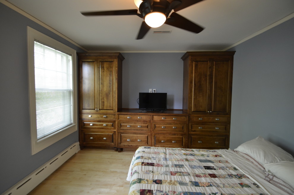 Foto de dormitorio principal clásico con paredes azules y suelo de madera clara