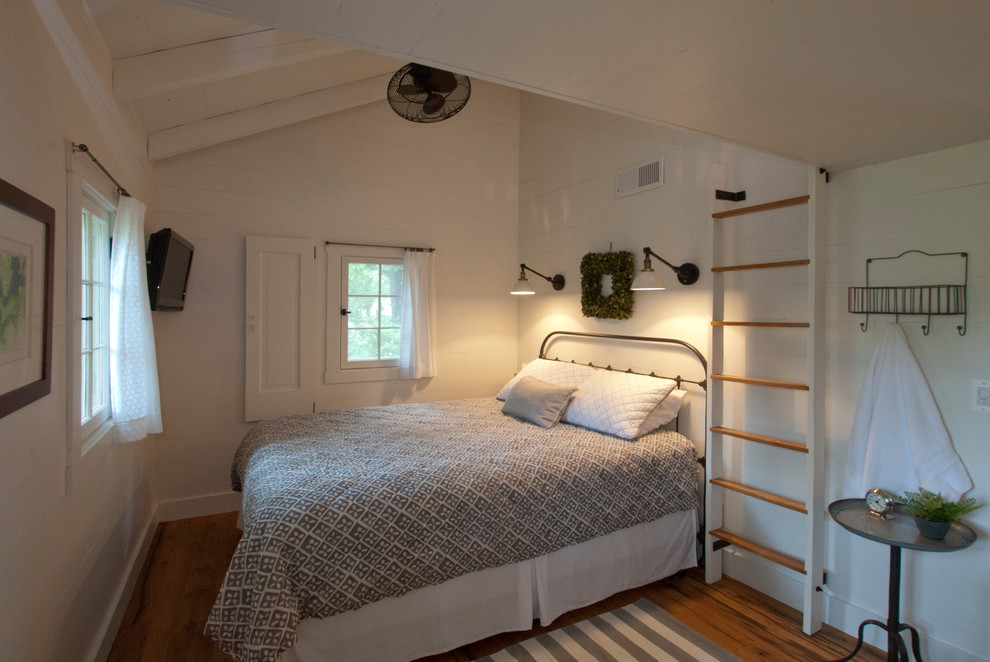 Foto di una camera da letto stile marino con pareti bianche e pavimento in legno massello medio