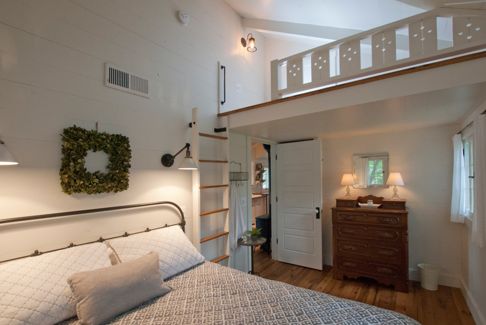 Bedroom - coastal medium tone wood floor bedroom idea in Other with white walls