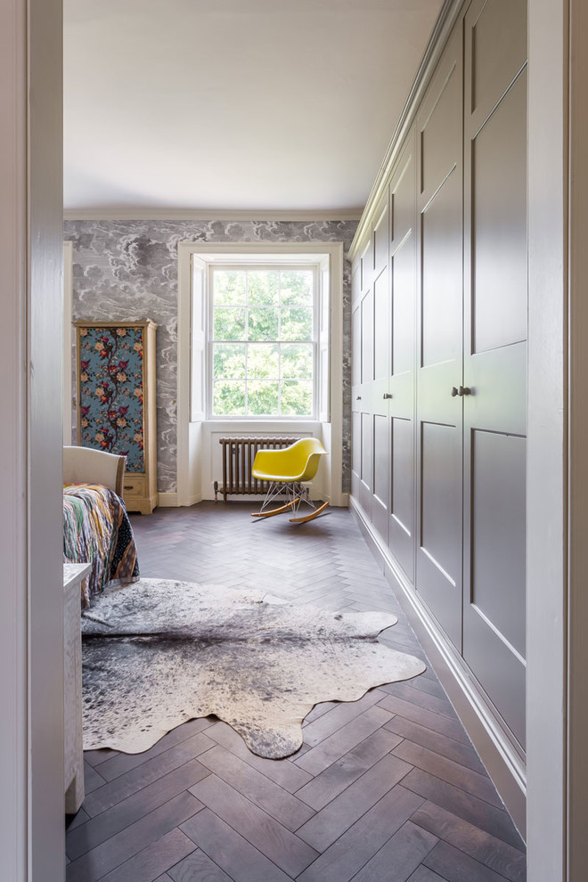Idée de décoration pour une grande chambre parentale design avec un mur gris, parquet foncé et un sol marron.