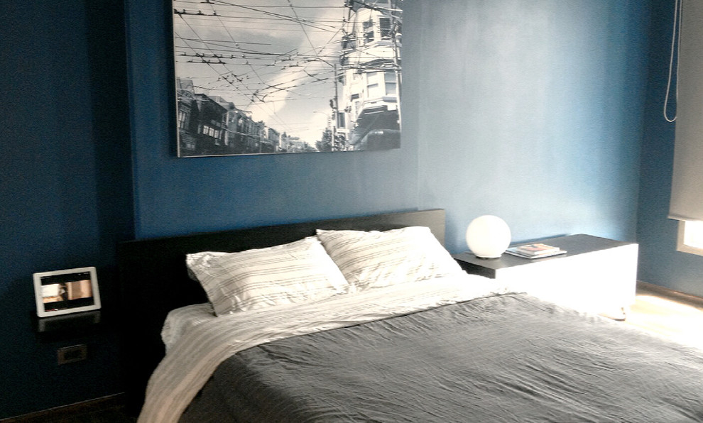Inspiration pour une petite chambre parentale minimaliste avec un mur bleu, parquet foncé et aucune cheminée.