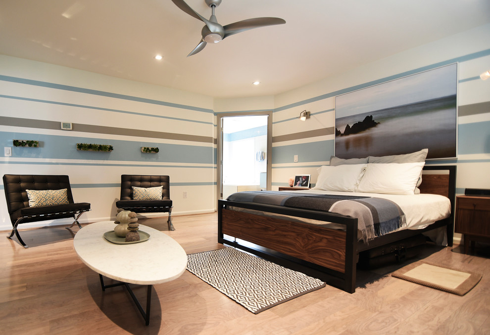 Imagen de habitación de invitados minimalista grande sin chimenea con paredes azules y suelo de madera en tonos medios