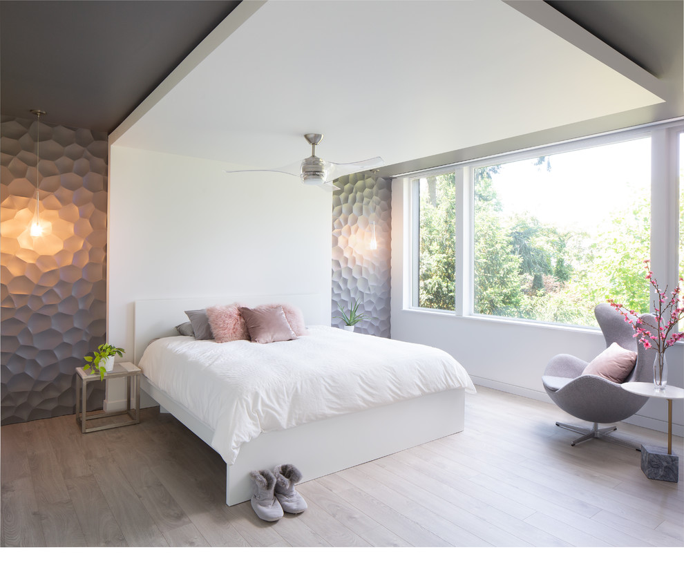 Ejemplo de dormitorio actual grande con paredes blancas, suelo de madera clara, suelo marrón y panelado