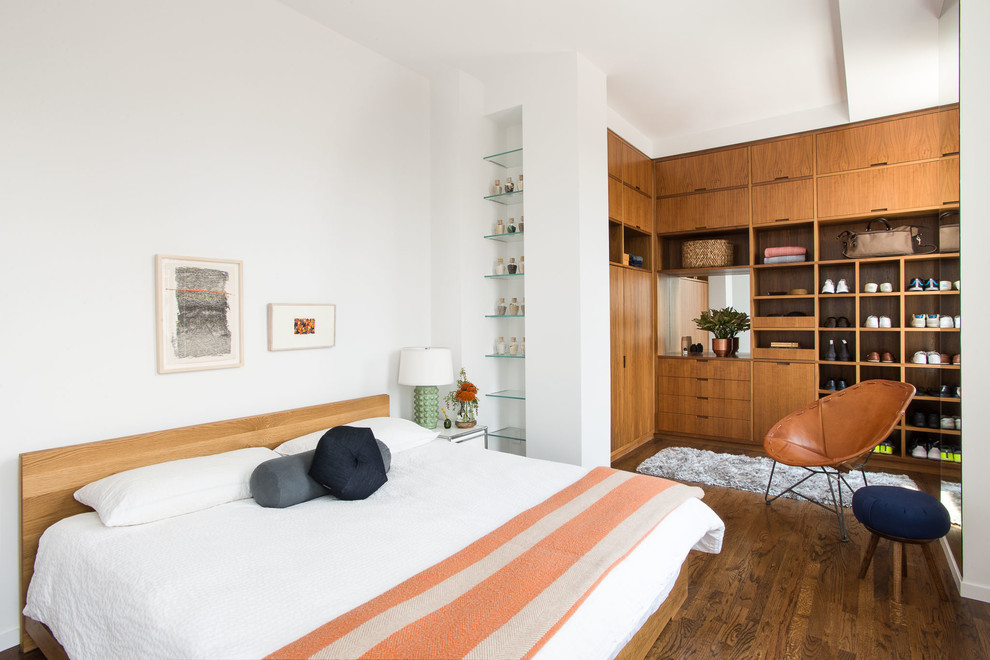 Aménagement d'une chambre contemporaine avec un mur blanc et un sol en bois brun.