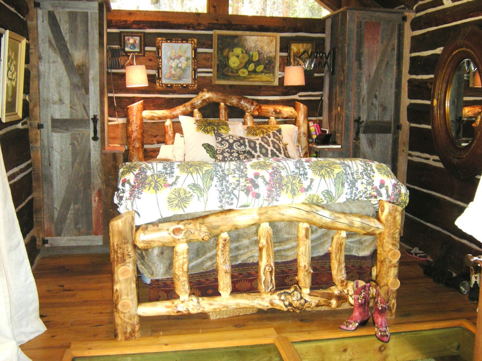 Kleines Rustikales Hauptschlafzimmer ohne Kamin mit brauner Wandfarbe und braunem Holzboden in Denver