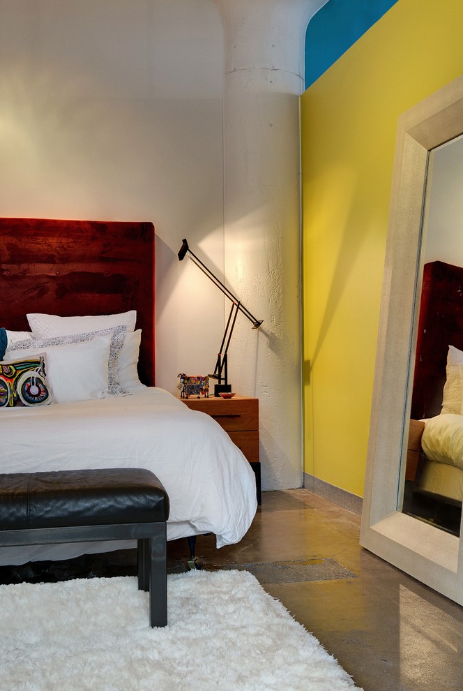 ミネアポリスにあるインダストリアルスタイルのおしゃれな寝室 (黄色い壁、コンクリートの床) のインテリア