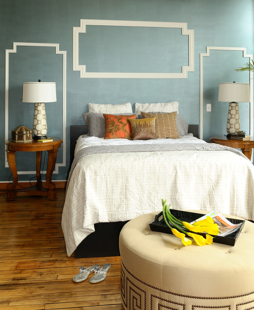 Example of a minimalist medium tone wood floor bedroom design in Minneapolis with blue walls