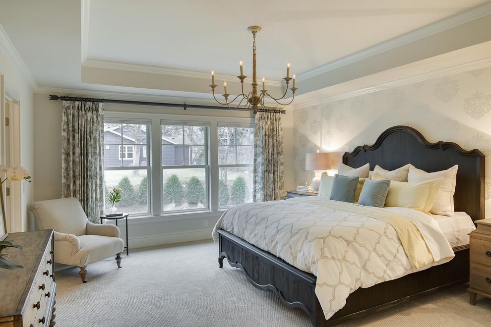 This is an example of a large traditional master bedroom in Minneapolis with yellow walls, carpet and no fireplace.