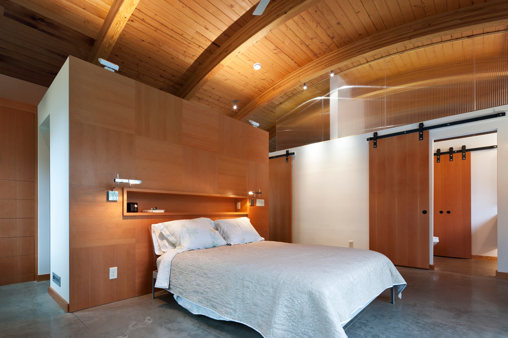 Foto de dormitorio minimalista con suelo de cemento