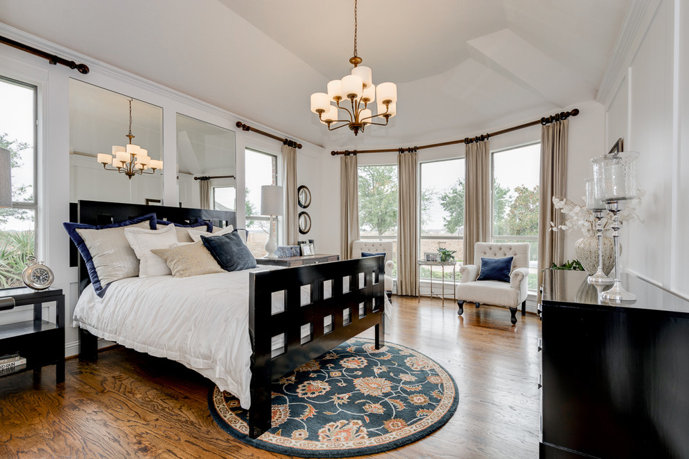 Klassisches Hauptschlafzimmer ohne Kamin mit weißer Wandfarbe und braunem Holzboden in Dallas