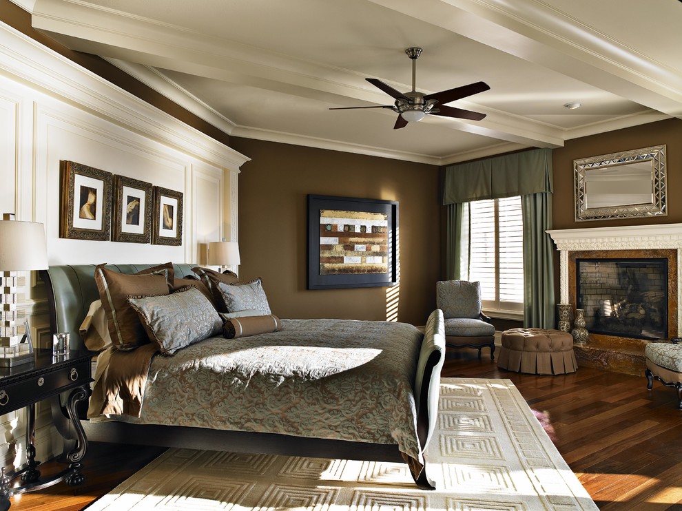 Mediterranes Hauptschlafzimmer mit brauner Wandfarbe, braunem Holzboden, Kamin und Kaminumrandung aus Backstein in Tampa