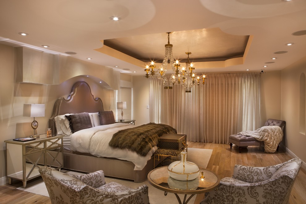 Modelo de dormitorio principal tradicional renovado extra grande sin chimenea con suelo de madera clara y paredes beige