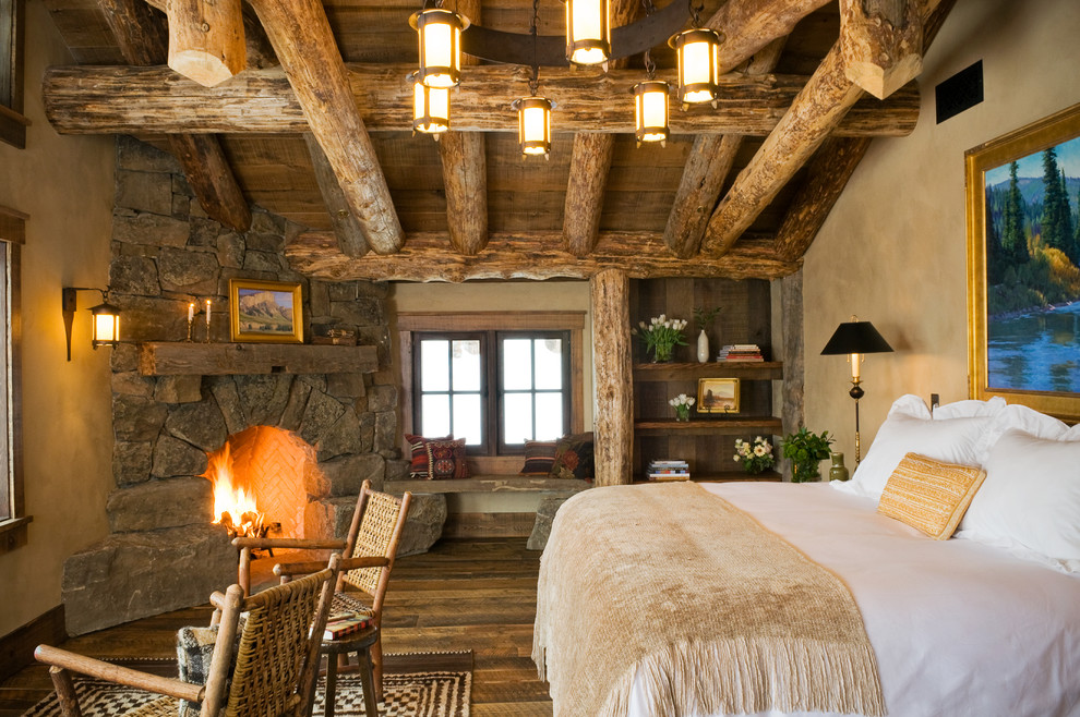 Inspiration pour une chambre chalet avec un mur marron, parquet foncé, une cheminée d'angle et un manteau de cheminée en pierre.