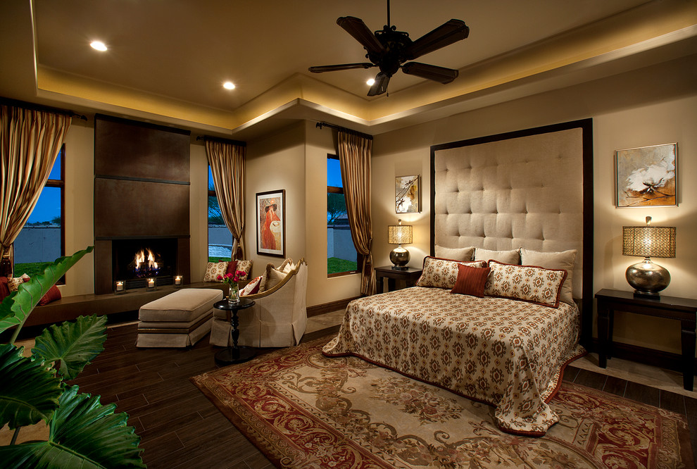 フェニックスにある広いトラディショナルスタイルのおしゃれな主寝室 (ベージュの壁、磁器タイルの床、標準型暖炉、金属の暖炉まわり)