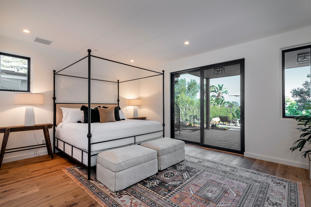 Inspiration for a large contemporary master bedroom in Santa Barbara with white walls, light hardwood flooring and brown floors.