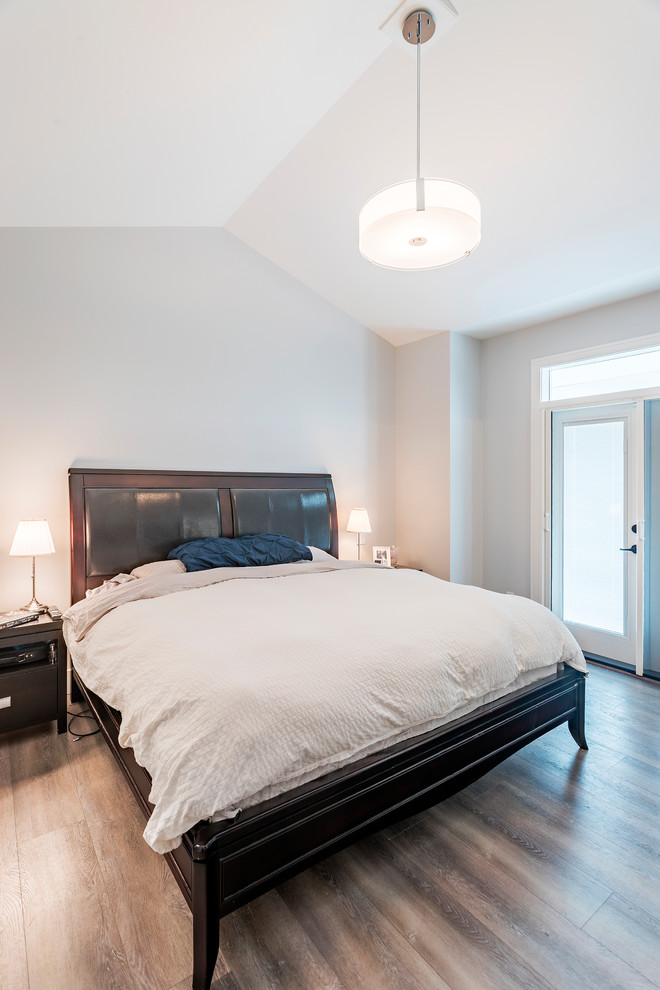Идея дизайна: хозяйская спальня среднего размера: освещение в классическом стиле с белыми стенами, полом из ламината и коричневым полом