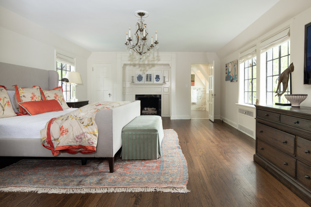 Inspiration för klassiska sovrum, med vita väggar, mörkt trägolv, en standard öppen spis och brunt golv