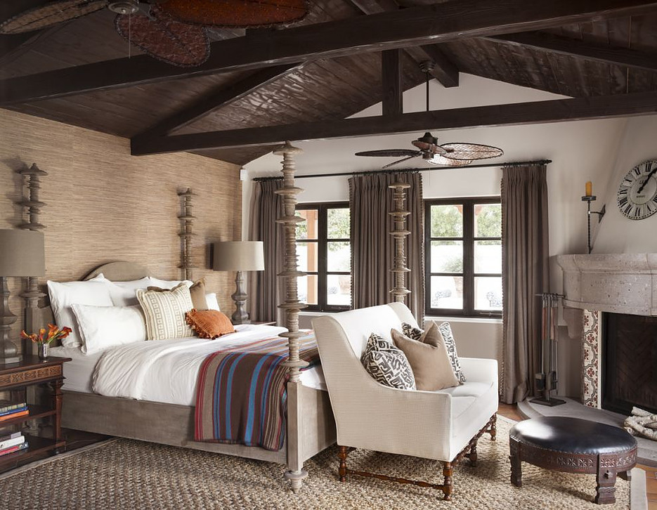 Ejemplo de dormitorio principal de estilo americano de tamaño medio con paredes beige, suelo de madera en tonos medios, chimenea de esquina, marco de chimenea de baldosas y/o azulejos y suelo marrón