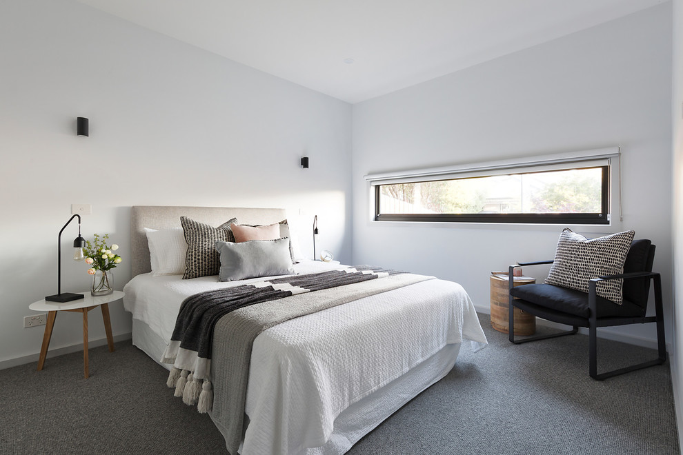 This is an example of a contemporary guest bedroom in Melbourne with white walls, carpet and grey floors.