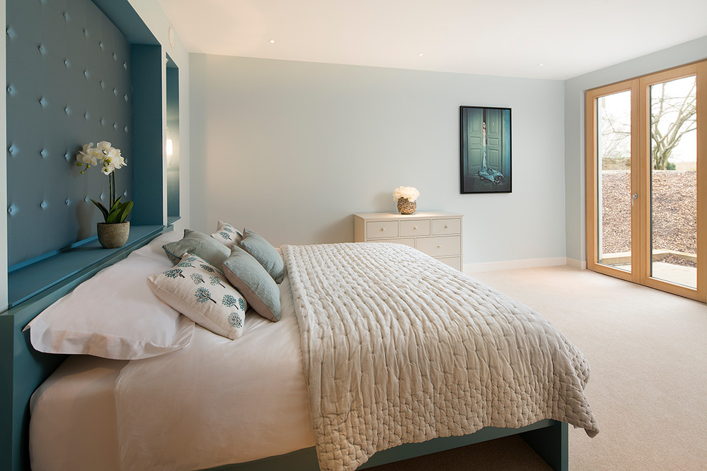 他の地域にあるトランジショナルスタイルのおしゃれな寝室 (青い壁、カーペット敷き、ベージュの床)