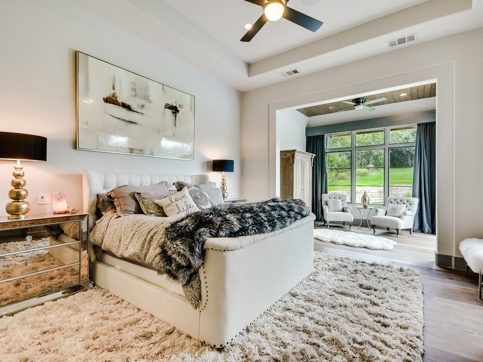 Mediterranes Hauptschlafzimmer mit weißer Wandfarbe, hellem Holzboden und beigem Boden in Austin