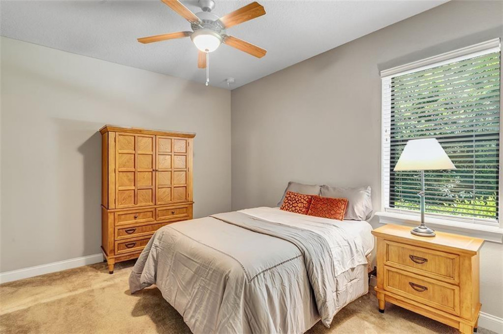 Mid-sized elegant guest carpeted and beige floor bedroom photo in Orlando with gray walls