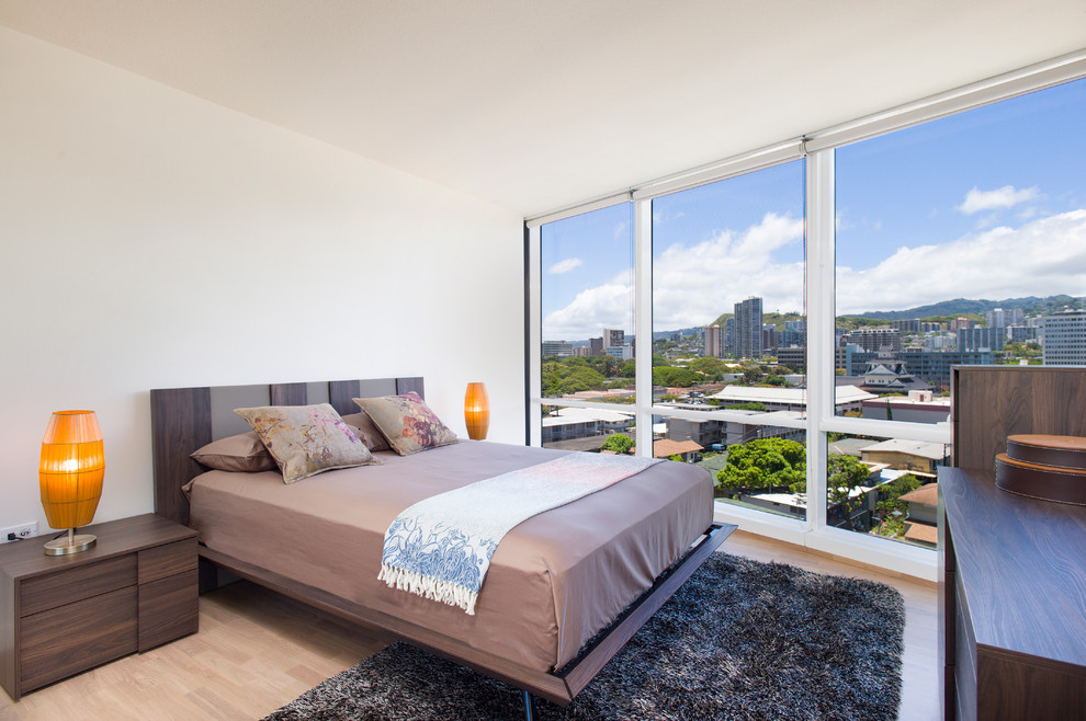 Modernes Schlafzimmer mit weißer Wandfarbe und hellem Holzboden in Hawaii