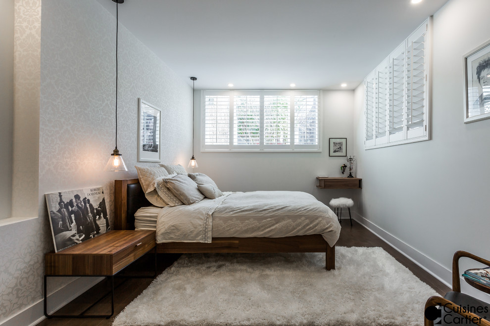 Ejemplo de habitación de invitados actual pequeña sin chimenea con paredes blancas y suelo de madera oscura