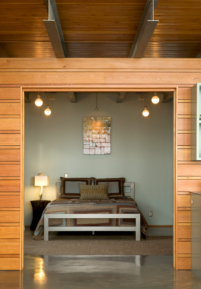 На фото: маленькая спальня в современном стиле с серыми стенами и бетонным полом для на участке и в саду