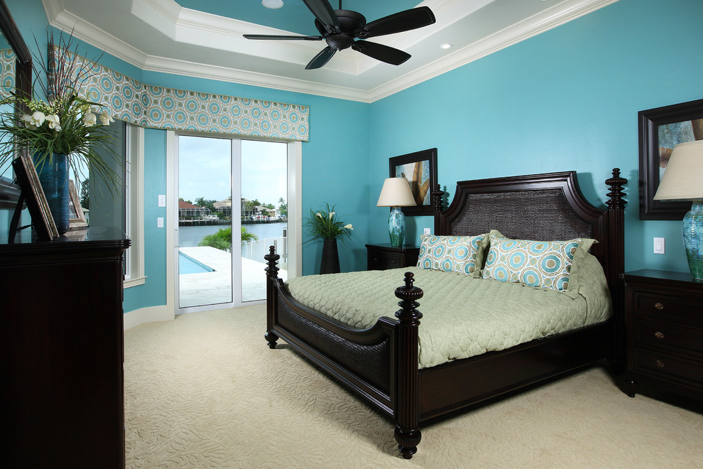Imagen de dormitorio principal costero grande sin chimenea con paredes azules y moqueta