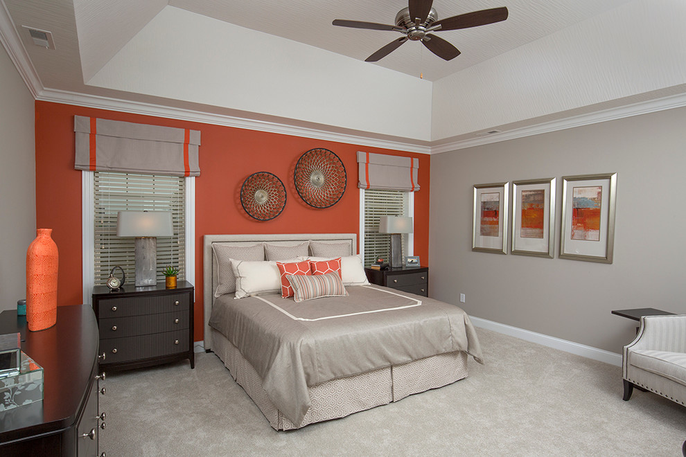 Foto på ett stort funkis gästrum, med orange väggar och heltäckningsmatta
