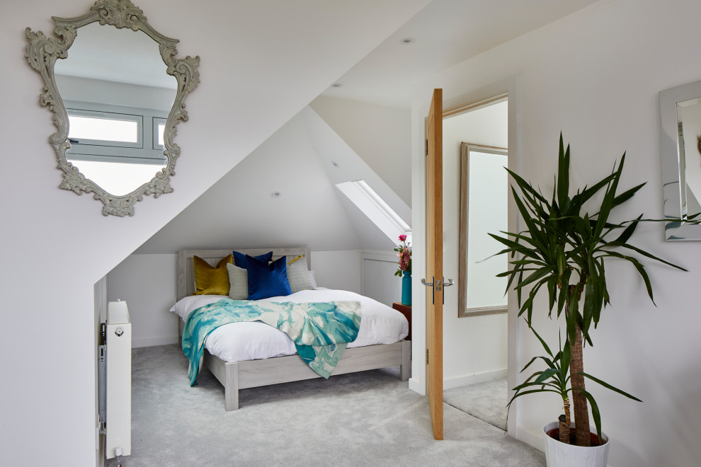 This is an example of a medium sized contemporary guest bedroom in London with white walls, carpet and grey floors.