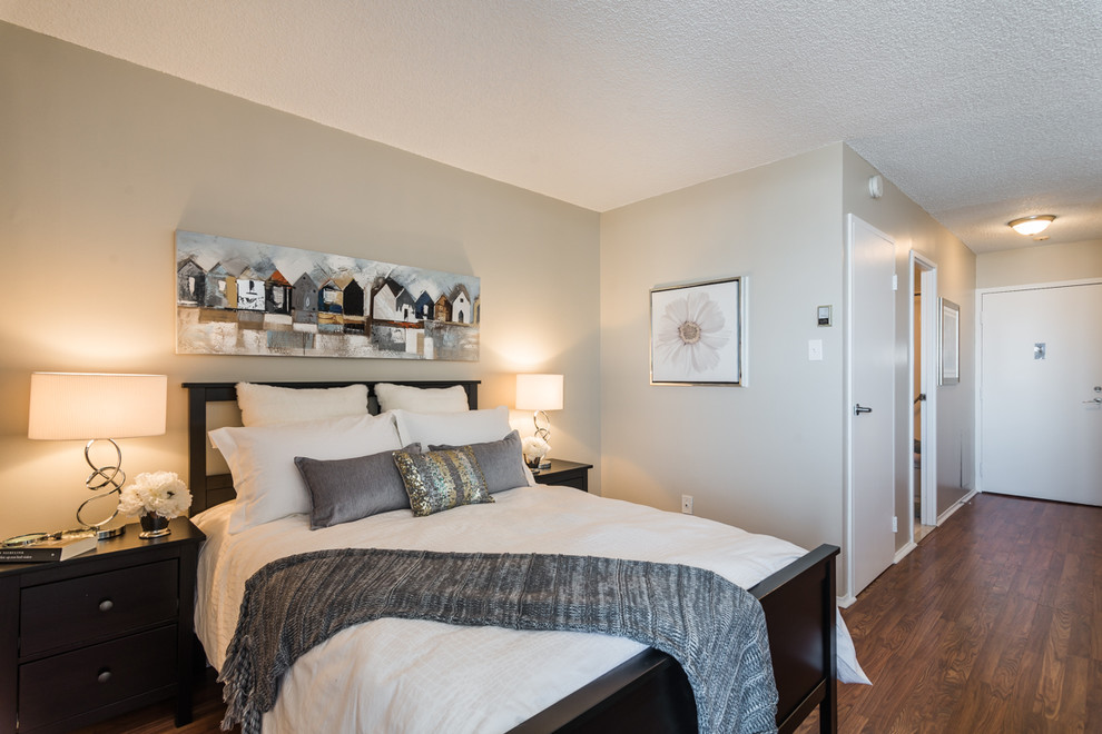 Imagen de dormitorio principal actual pequeño con paredes beige y suelo de madera en tonos medios