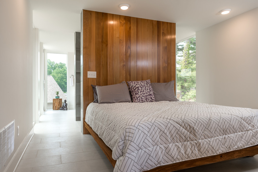 This is an example of an expansive modern master bedroom in New York with white walls, ceramic flooring, no fireplace and white floors.