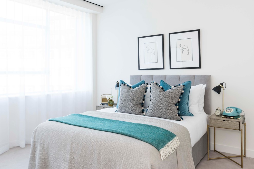 Photo of a contemporary grey and teal bedroom in London with white walls, carpet and grey floors.