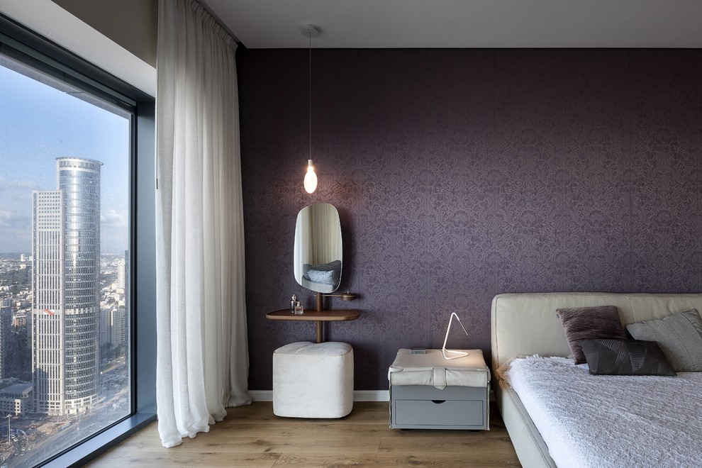 Inspiration pour une chambre design avec un mur violet, un sol en bois brun et un sol marron.