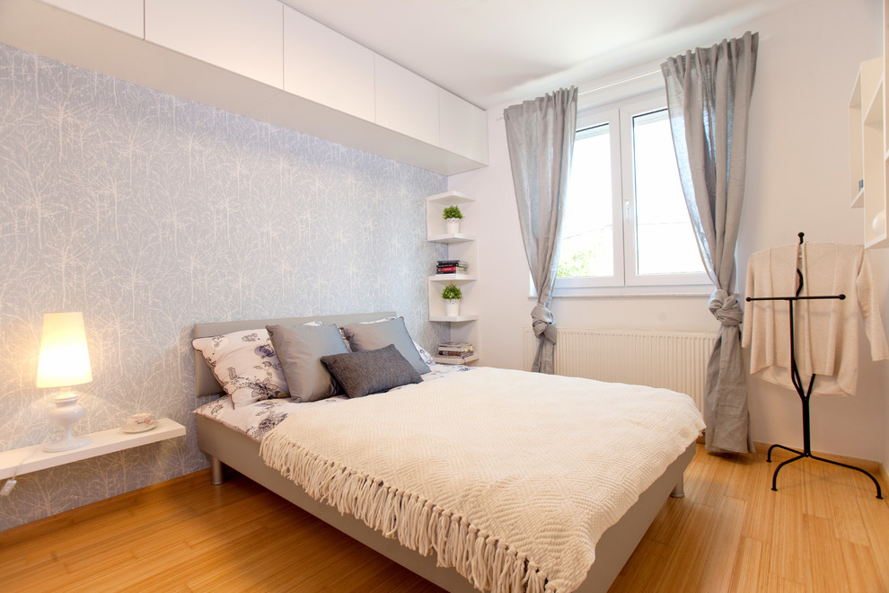 Kleines Modernes Hauptschlafzimmer ohne Kamin mit weißer Wandfarbe und hellem Holzboden in Sonstige