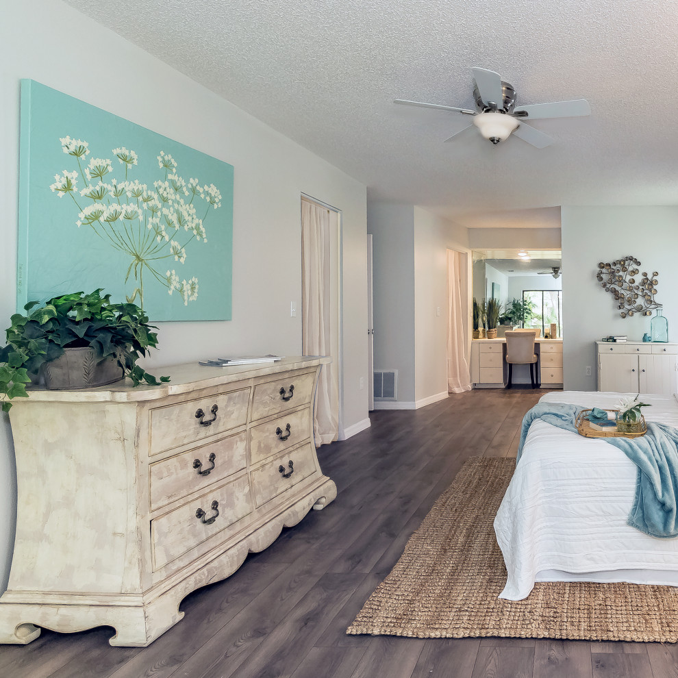 Photo of a large coastal master bedroom in Tampa with grey walls, medium hardwood flooring and grey floors.