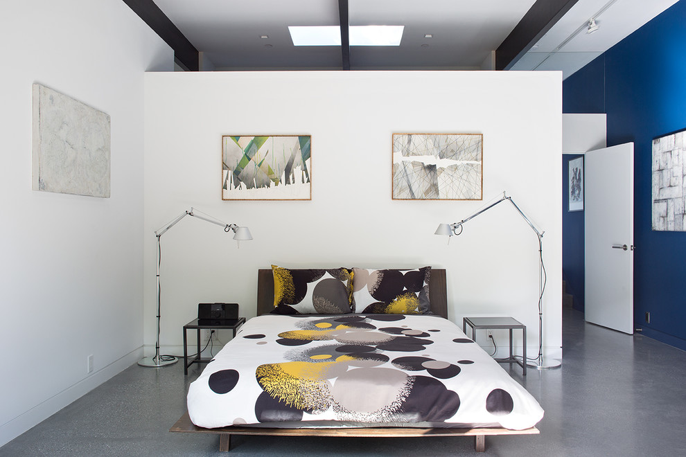 Стильный дизайн: спальня в современном стиле с белыми стенами и бетонным полом - последний тренд