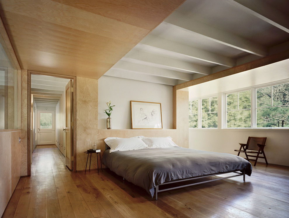 Example of a trendy light wood floor bedroom design in New York with white walls